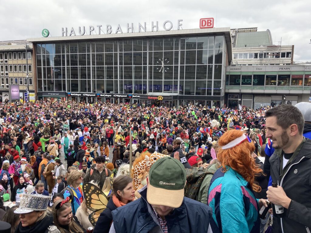 Menschenmenge in Kostümen vor dem Kölner Hauptbahnhof