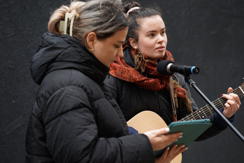 Zwei Frauen singen mit Gitarre